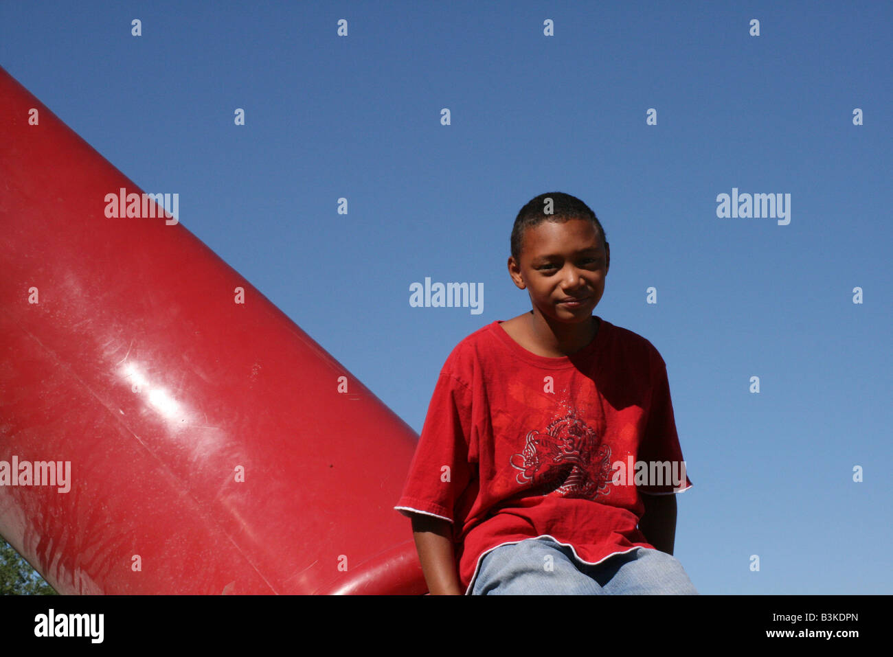 African American boy su attrezzature per parchi gioco Foto Stock