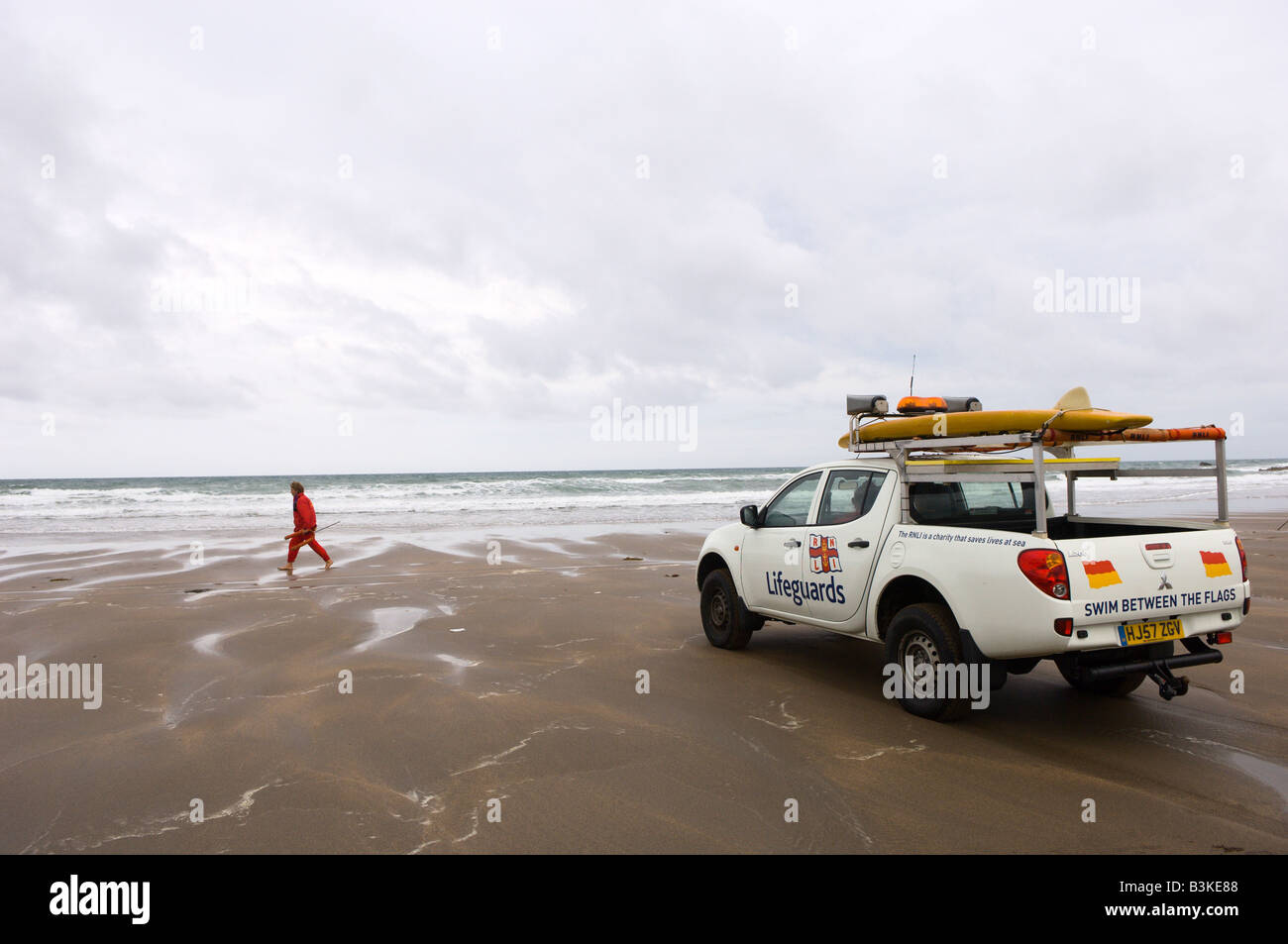 Bagnini sondaggio una spiaggia deserta da loro pick up truck a Widemouth Bay Cornwall Gran Bretagna Europa Foto Stock