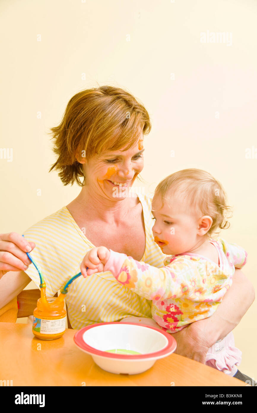 Madre di alimentazione bambino disordinato Foto Stock