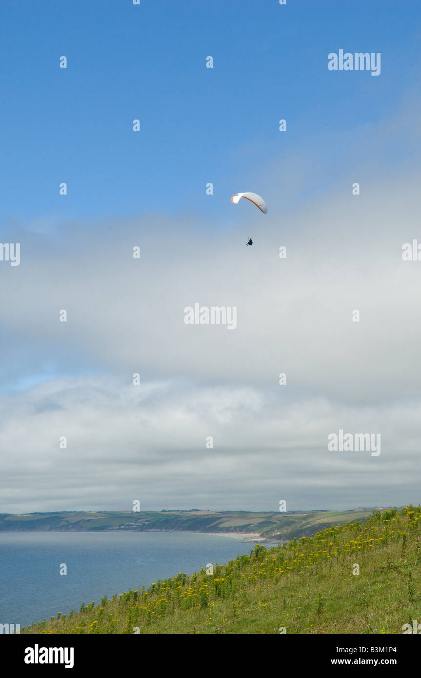 Un parapendio vola lungo le scogliere a Polhawn Whitsand Bay Torpoint Cornovaglia Gran Bretagna Foto Stock
