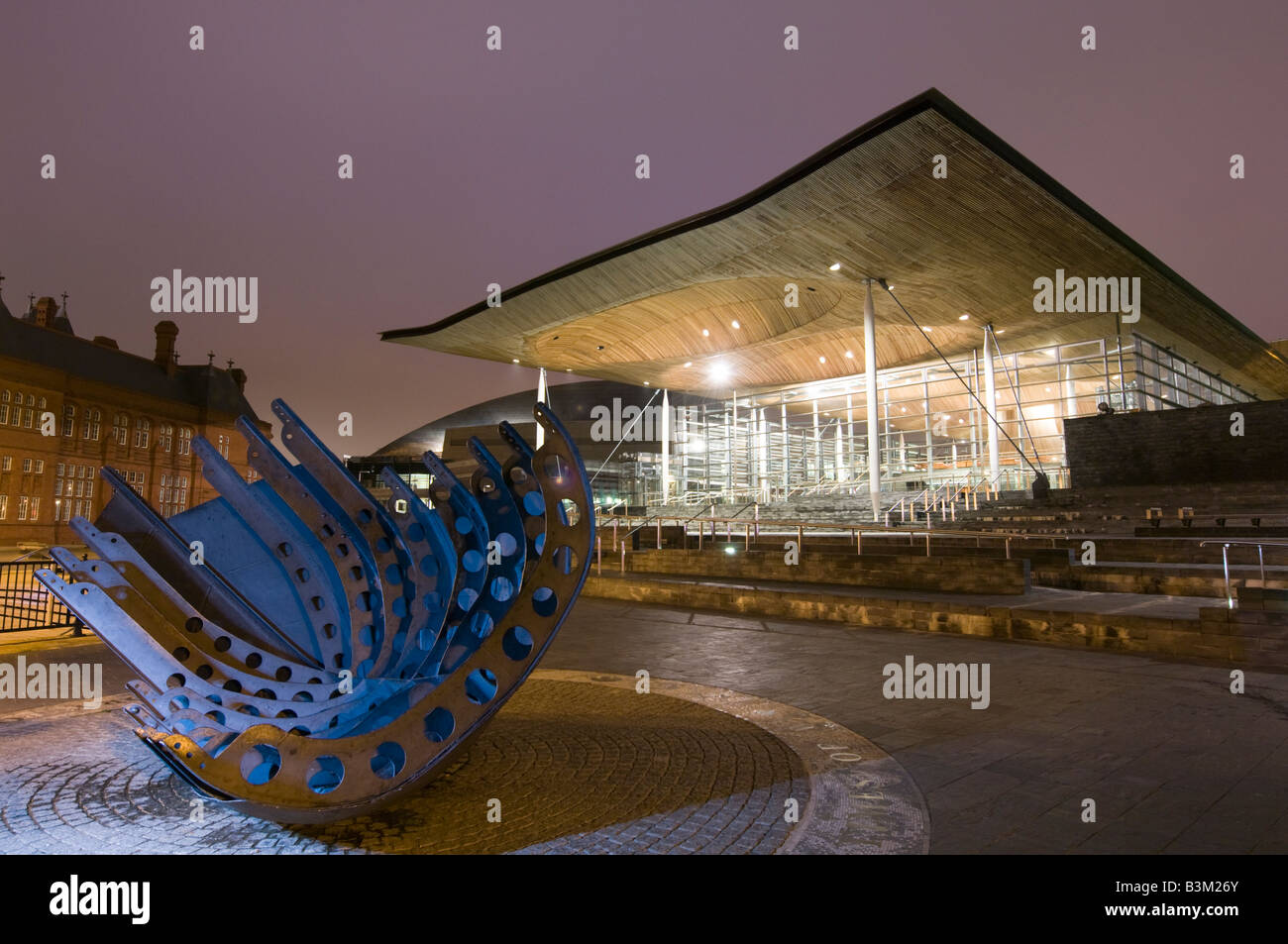 Esterno Assemblea nazionale del Galles governo edificio Senedd Cardiff Bay Regno Unito alla notte, progettato dall architetto Richard Rogers Foto Stock