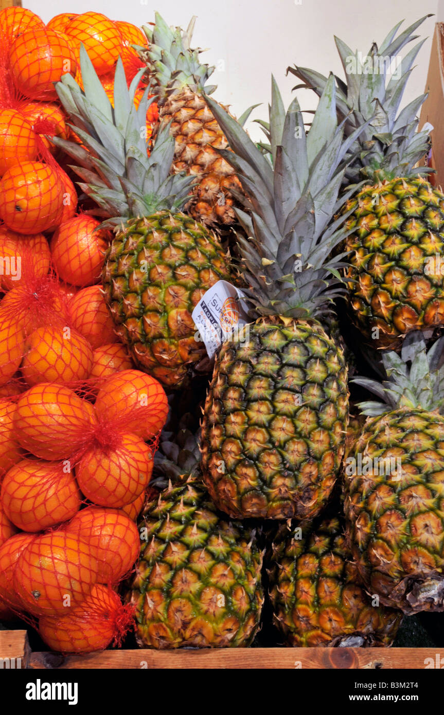 All'interno di Calcott Hall, negozio di frutta, prodotti da frutta in esposizione da vicino di ananas e sacchetti di arance Brentwood Essex Inghilterra Regno Unito Foto Stock