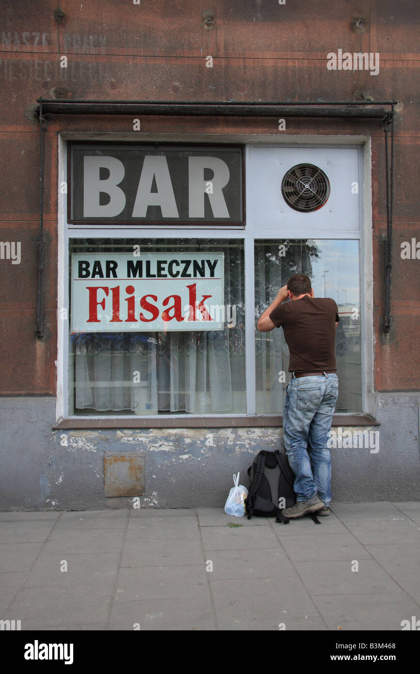 L'uomo guarda attraverso la finestra di 'Flisak' latte ba o Bar Mleczny, a Cracovia, Polonia Foto Stock