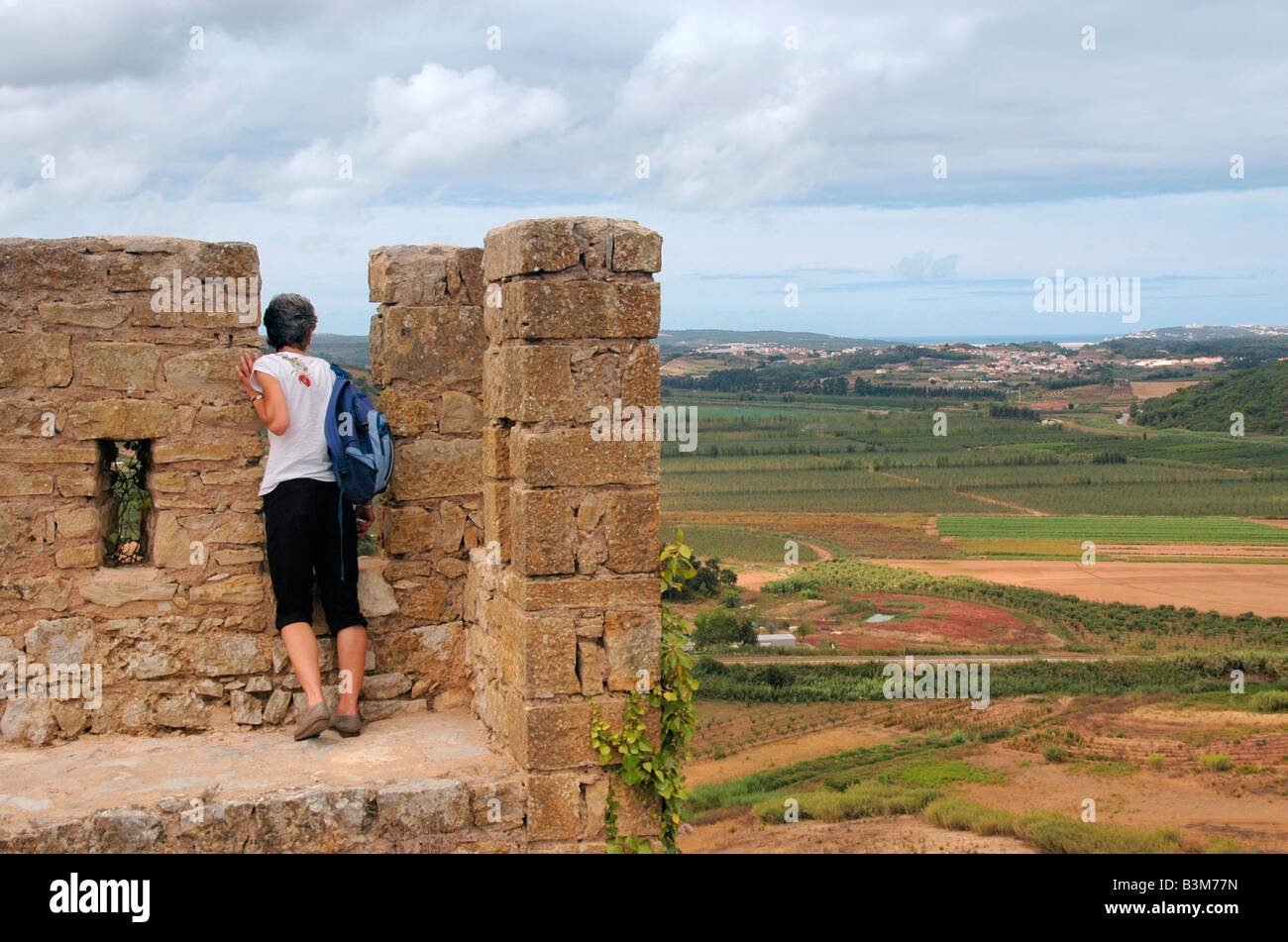 Una donna si ferma per visualizzare il paesaggio circostante dalle mura - mura del castello - delle conserve mediaevel città di Obidos, Foto Stock