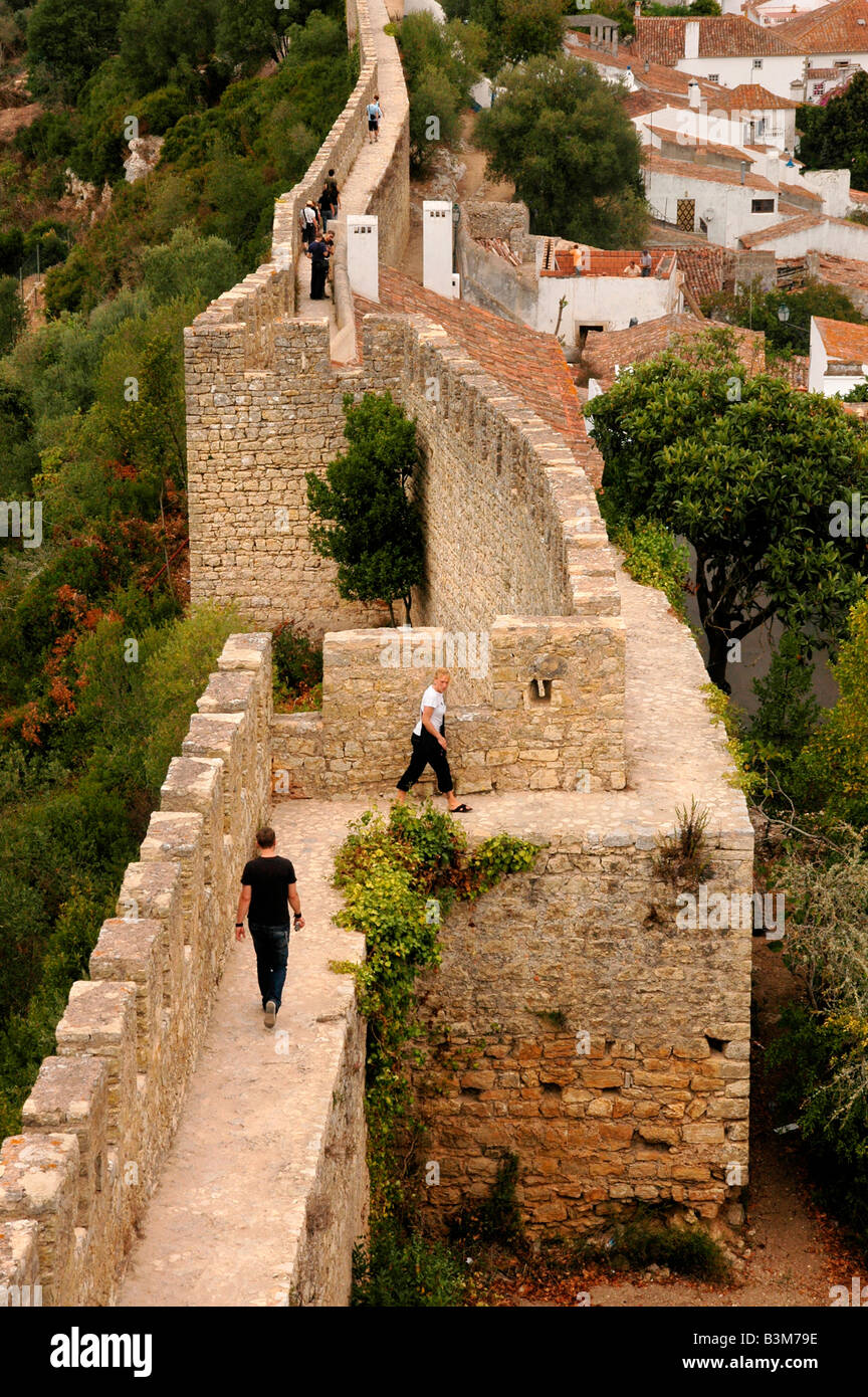 La gente a piedi lungo i bastioni delle conserve mediaevel città di Obidos, Portogallo. Foto Stock