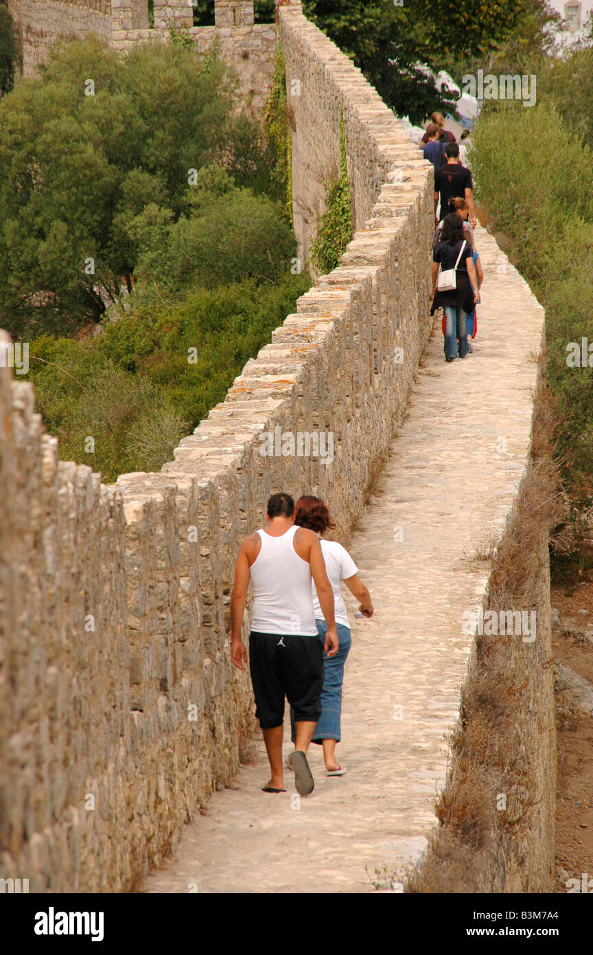 La gente a piedi lungo i bastioni delle conserve mediaevel città di Obidos, Portogallo. Foto Stock