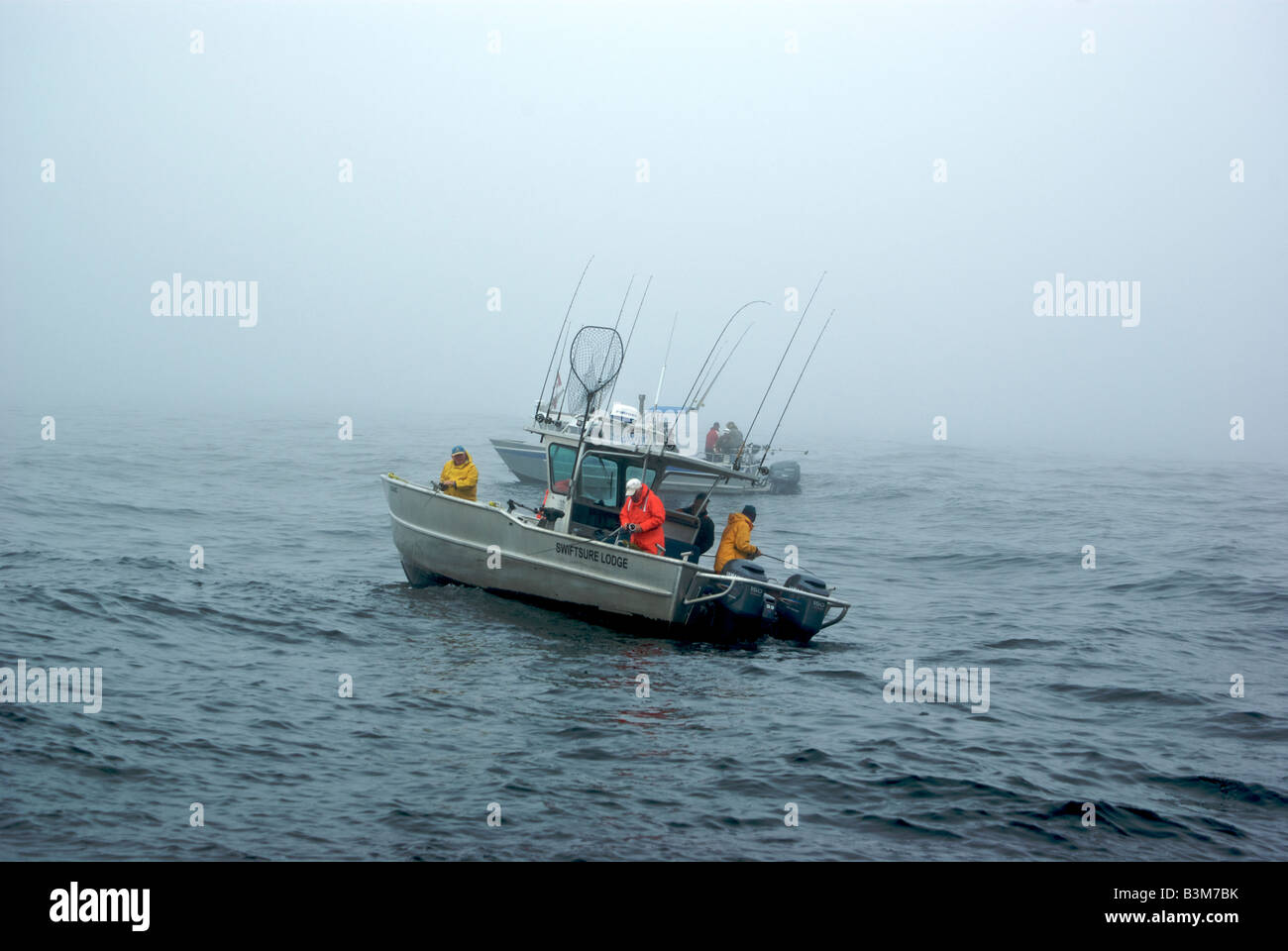 I pescatori a bordo di alluminio charter barche da pesca pesca halibut in mare mosso e la nebbia sulla banca Swiftsure nell'Oceano Pacifico Foto Stock