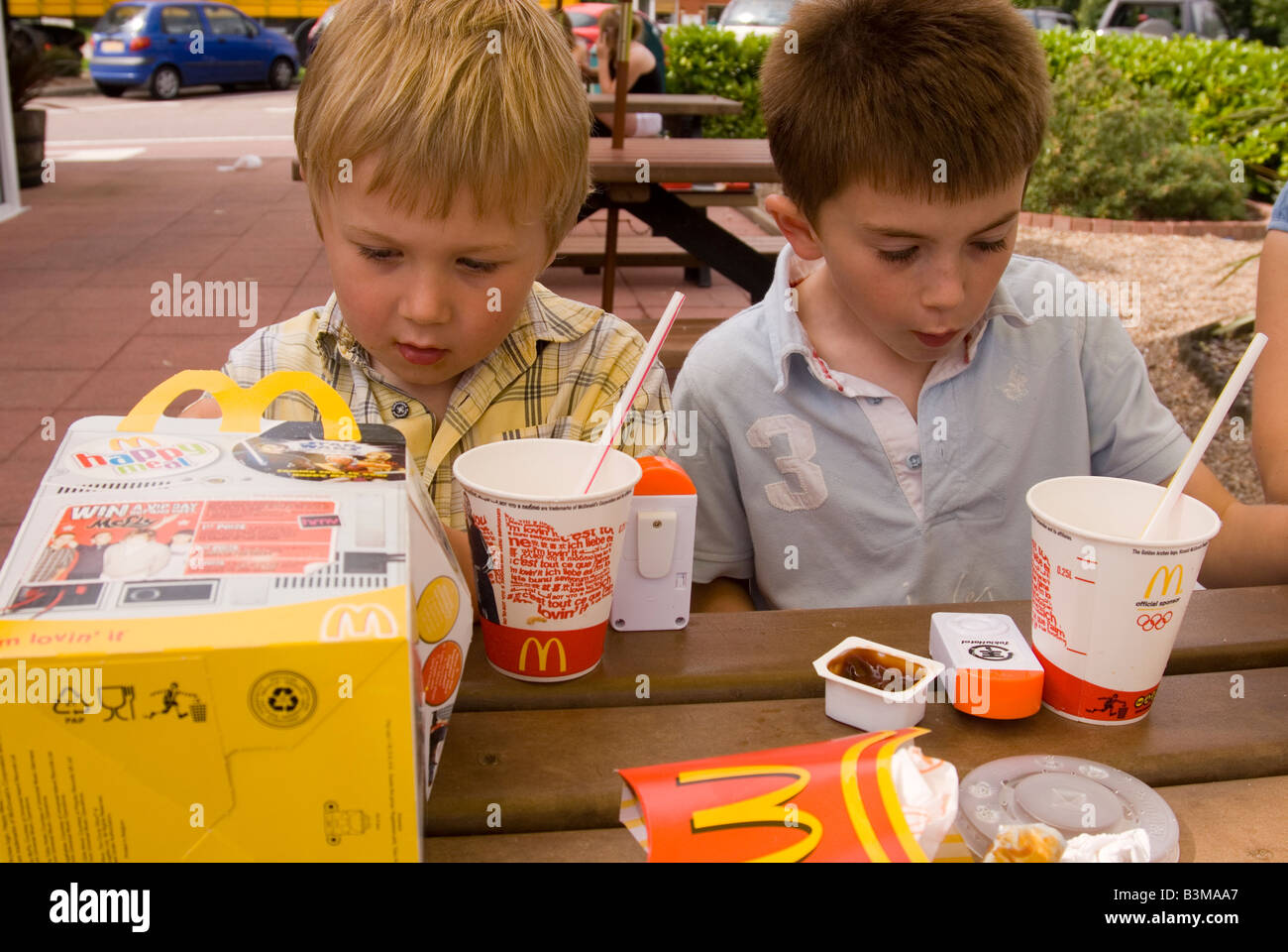 Due ragazzi di mangiare pasti auguri al Mcdonald's Foto Stock