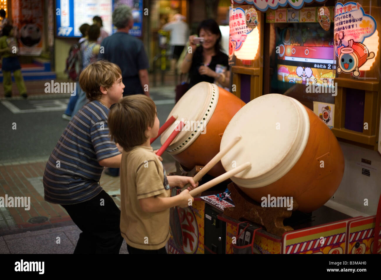 Due bambini giocano tamburo taiko video gioco di Shinjuku, Tokyo Giappone Foto Stock