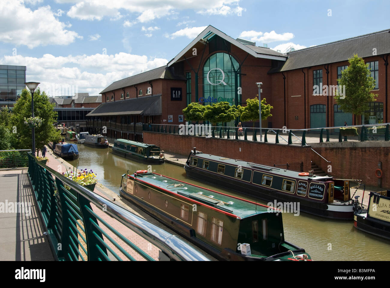 Strette barche ormeggiate sul canale di Oxford al castello di Quays shopping centre, Banbury, Oxfordshire, Regno Unito. Foto Stock