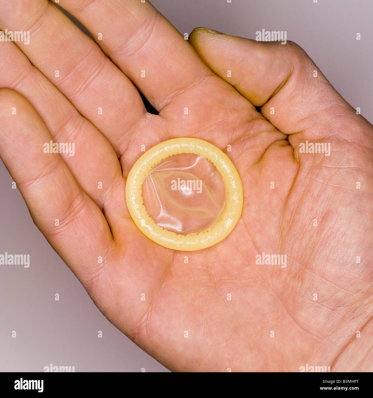 Il preservativo sulla mano d'uomo, vista in elevazione, close-up Foto stock  - Alamy