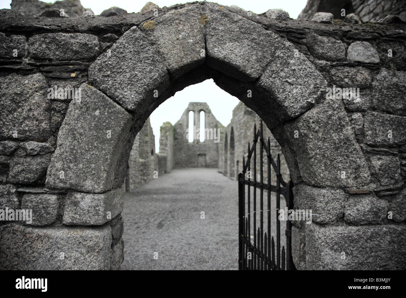 Arco in pietra del gateway/porta ad una chiesa abbandonata in Irlanda paesaggio Foto Stock