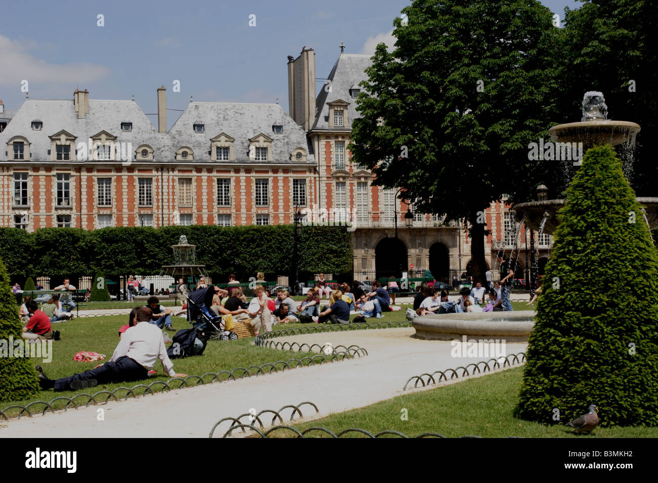 Francia Paris parigini per godersi il sole in Piazza Luigi XIII in Place des Vosges Foto Stock