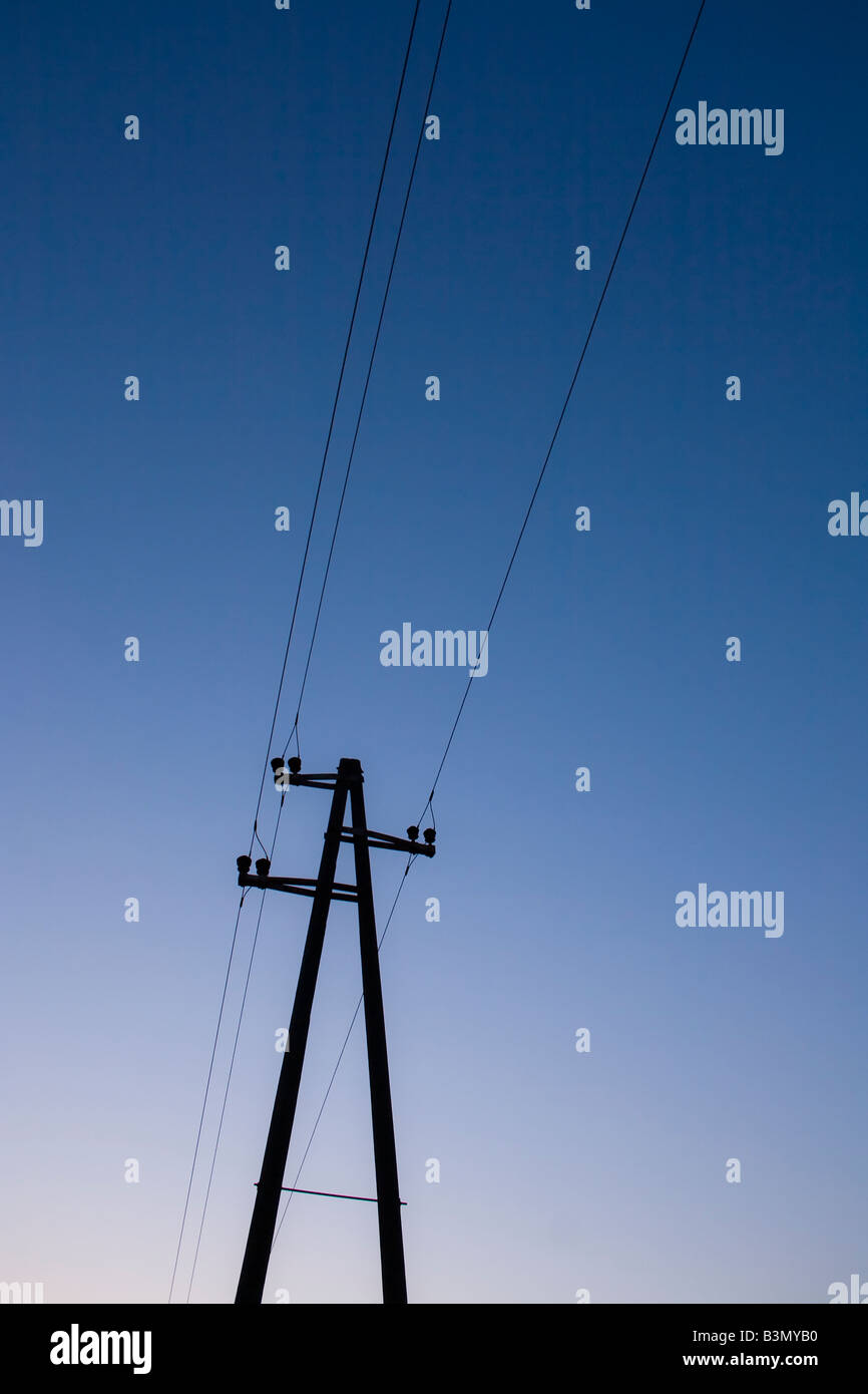 Polo elettrico silhouette contro un cielo blu. Foto Stock