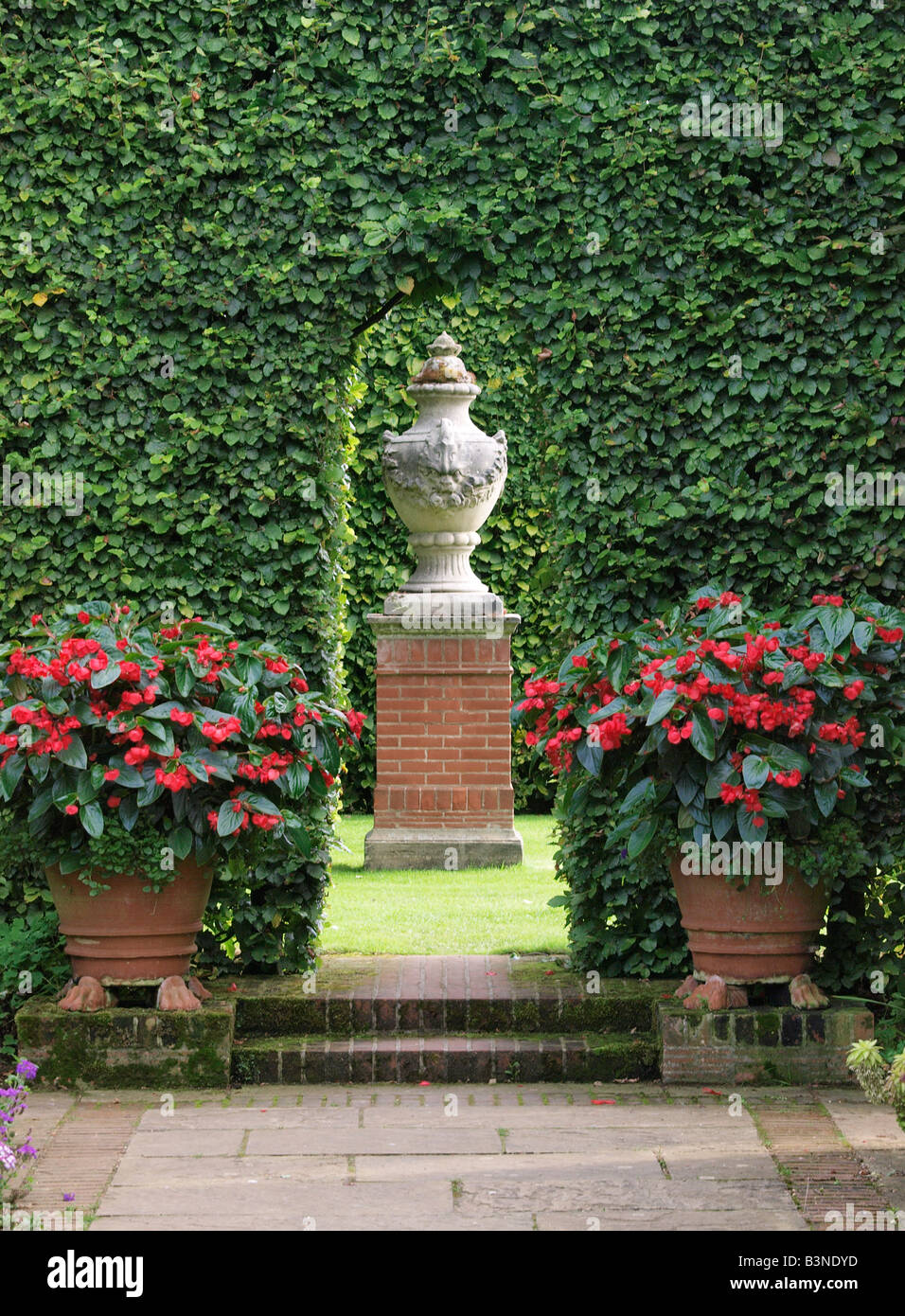 Percorso con vista attraverso il foro nella copertura dell'urna ornamentali sul plinto di mattoni east ruston old vicarage giardino norfolk England Regno Unito Foto Stock