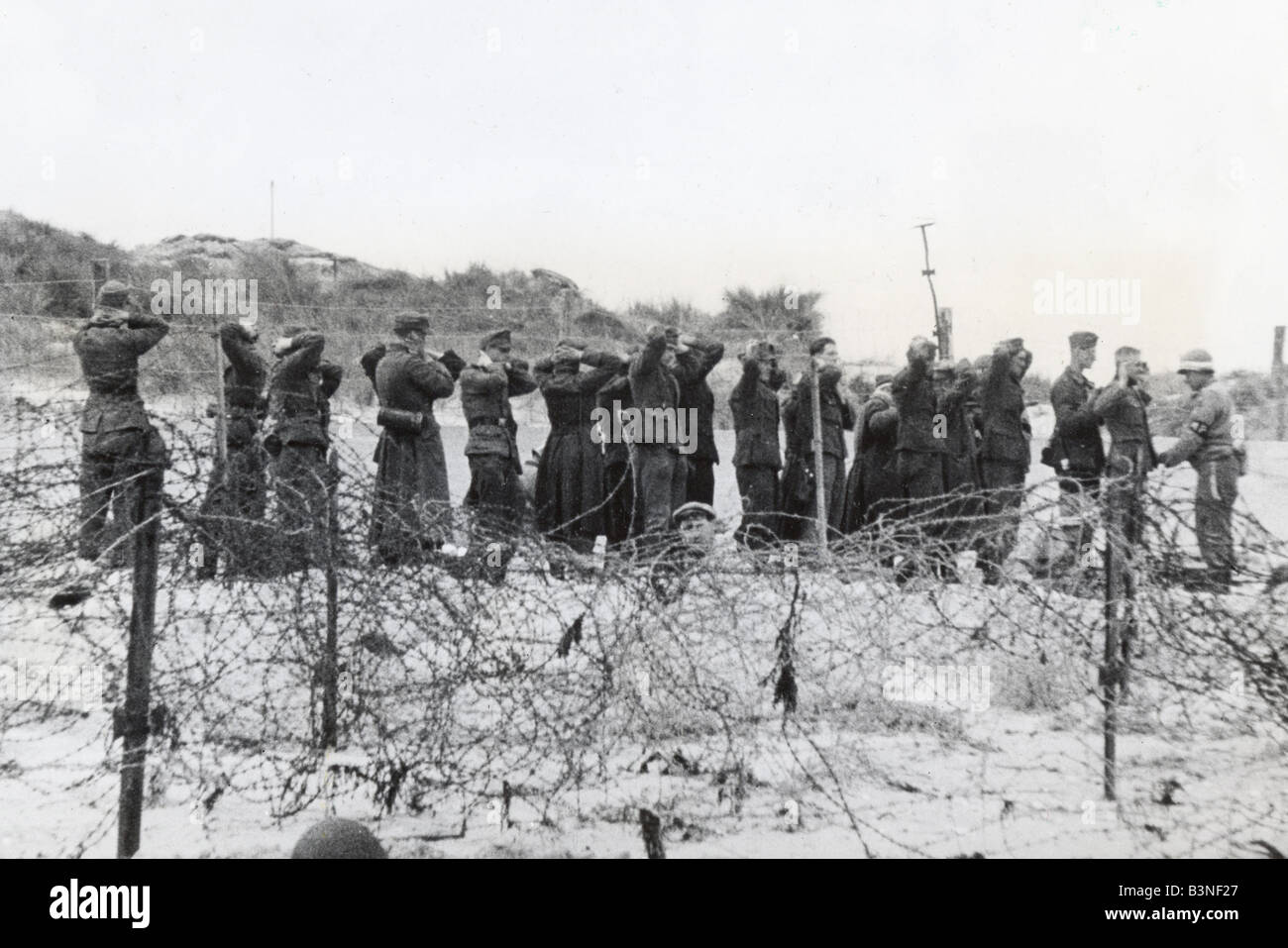 D-giorno 6 giugno 1944 - prigionieri tedeschi vengono ricercati da parte di un soldato americano Foto Stock
