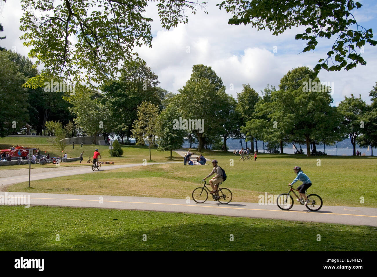 I ciclisti corrono lungo il percorso Seawall in Stanley Park a Vancouver British Columbia Canada Foto Stock