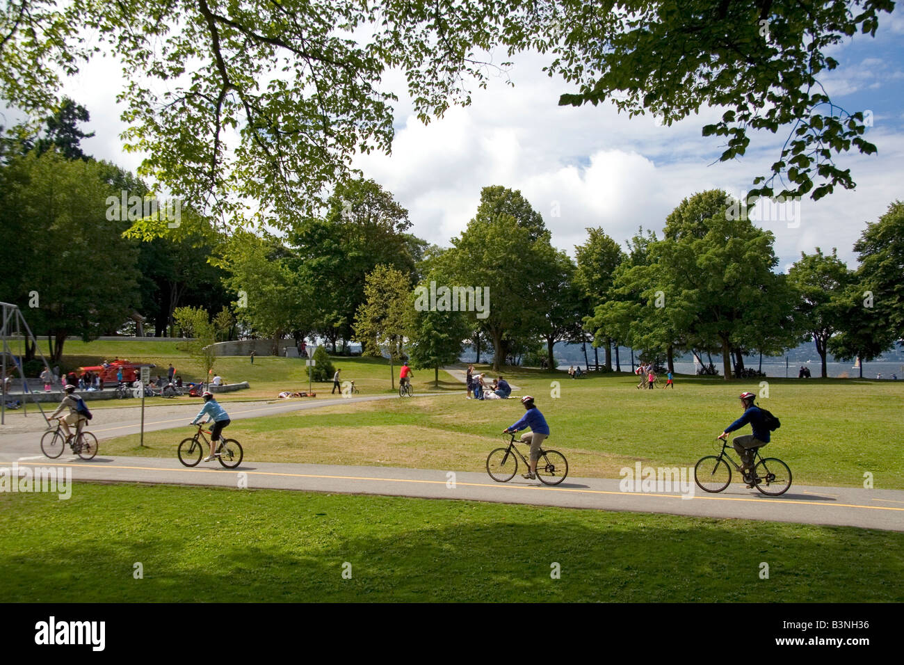 I ciclisti corrono lungo il percorso Seawall in Stanley Park a Vancouver British Columbia Canada Foto Stock