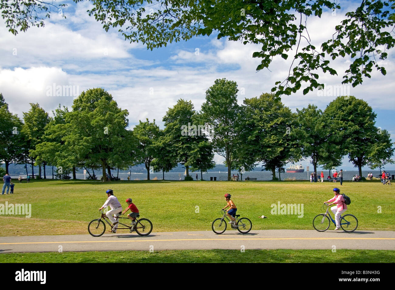 I ciclisti corrono lungo il percorso Seawall in Stanley Park a Vancouver British Columbia Canada Foto Stock