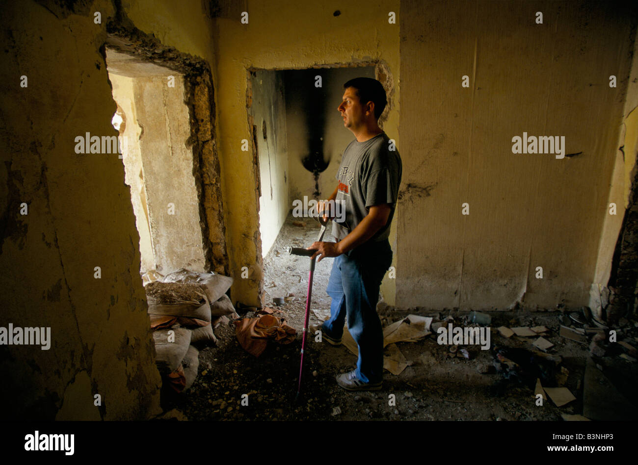 Mostar, giugno 1996', Alen kaytaz,ex combattente e ferito 3 volte nella stessa gamba, sorge in resti di un edificio, 1996 Foto Stock