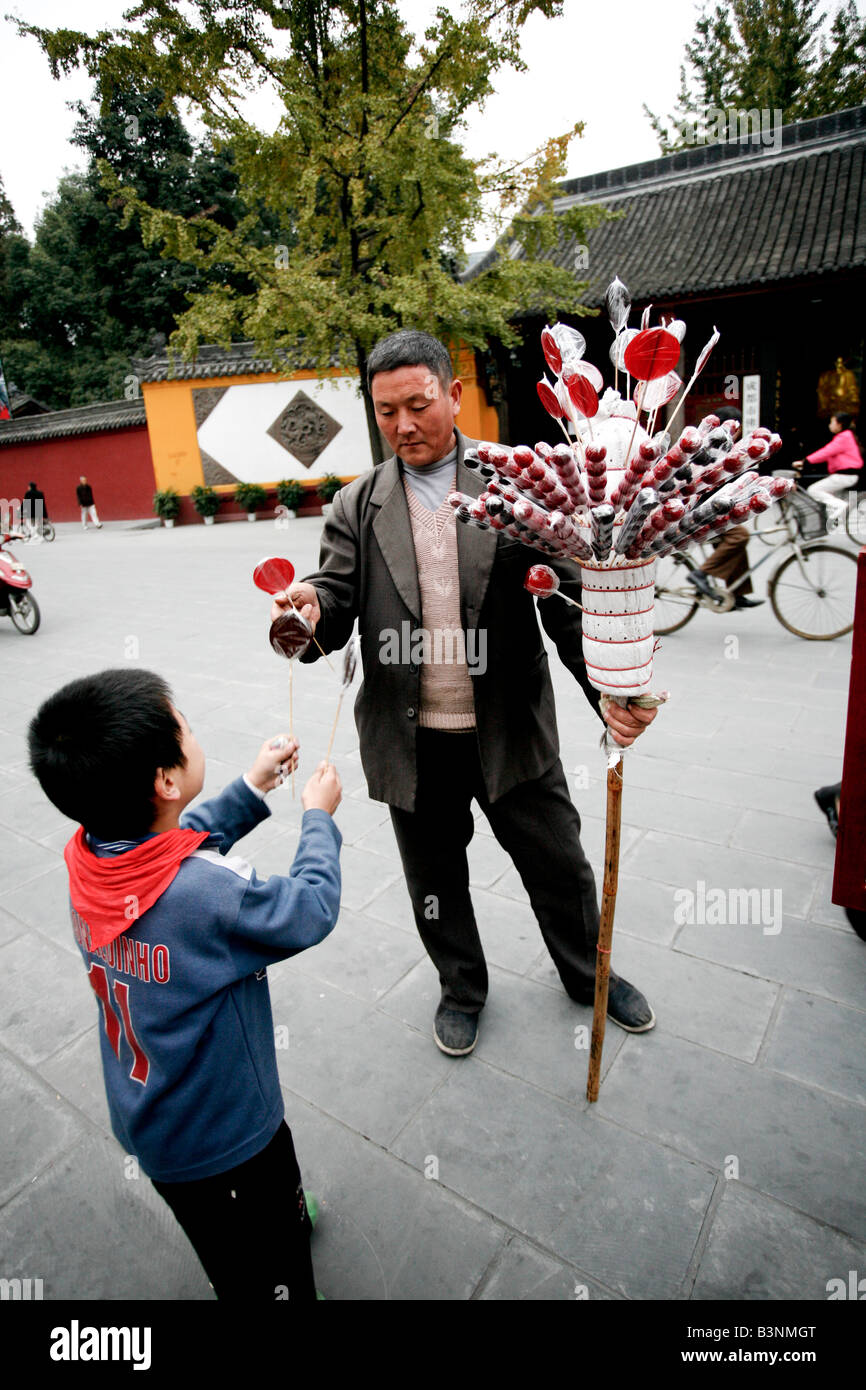 Chinese Boy acquisto di candy da uomo a Wen Shu Monastero Foto Stock