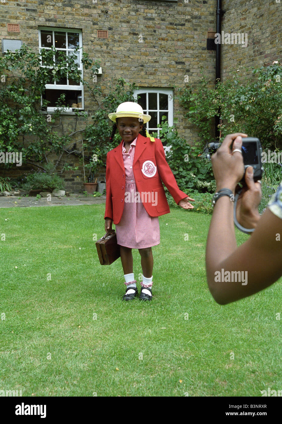 Madre nera prende una foto della figlia del primo giorno di scuola Foto Stock