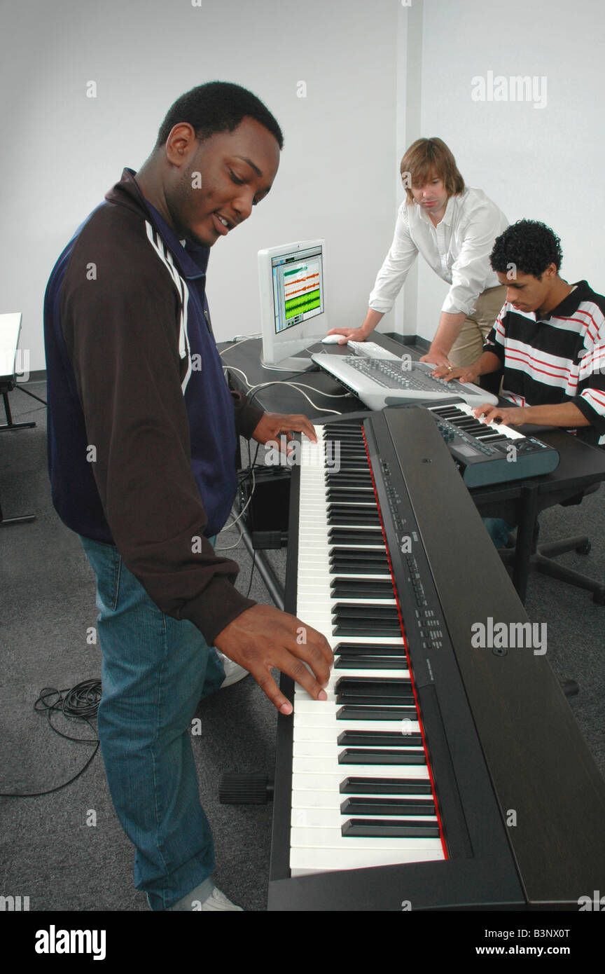 Gruppo giocando disponendo la composizione e la registrazione di musica in uno studio Foto Stock