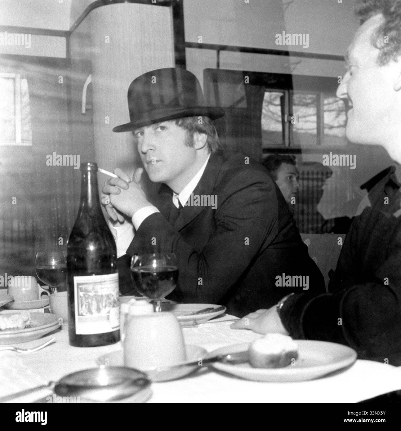 I Beatles Marzo 1964 John Lennon indossando un cappello bowler e fumare una  sigaretta al tavolo da pranzo durante il viaggio per South Molton Devon in  The Beatles treno speciale per le