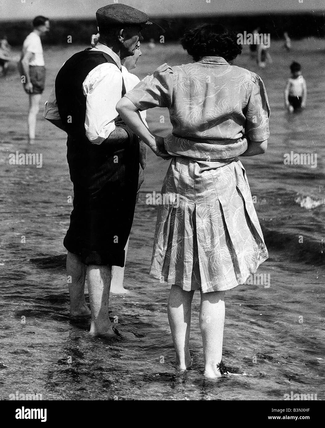 Anziani sulla banca di spiaggia in riva al fiume per vacanze di famiglia data sconosciuta Foto Stock