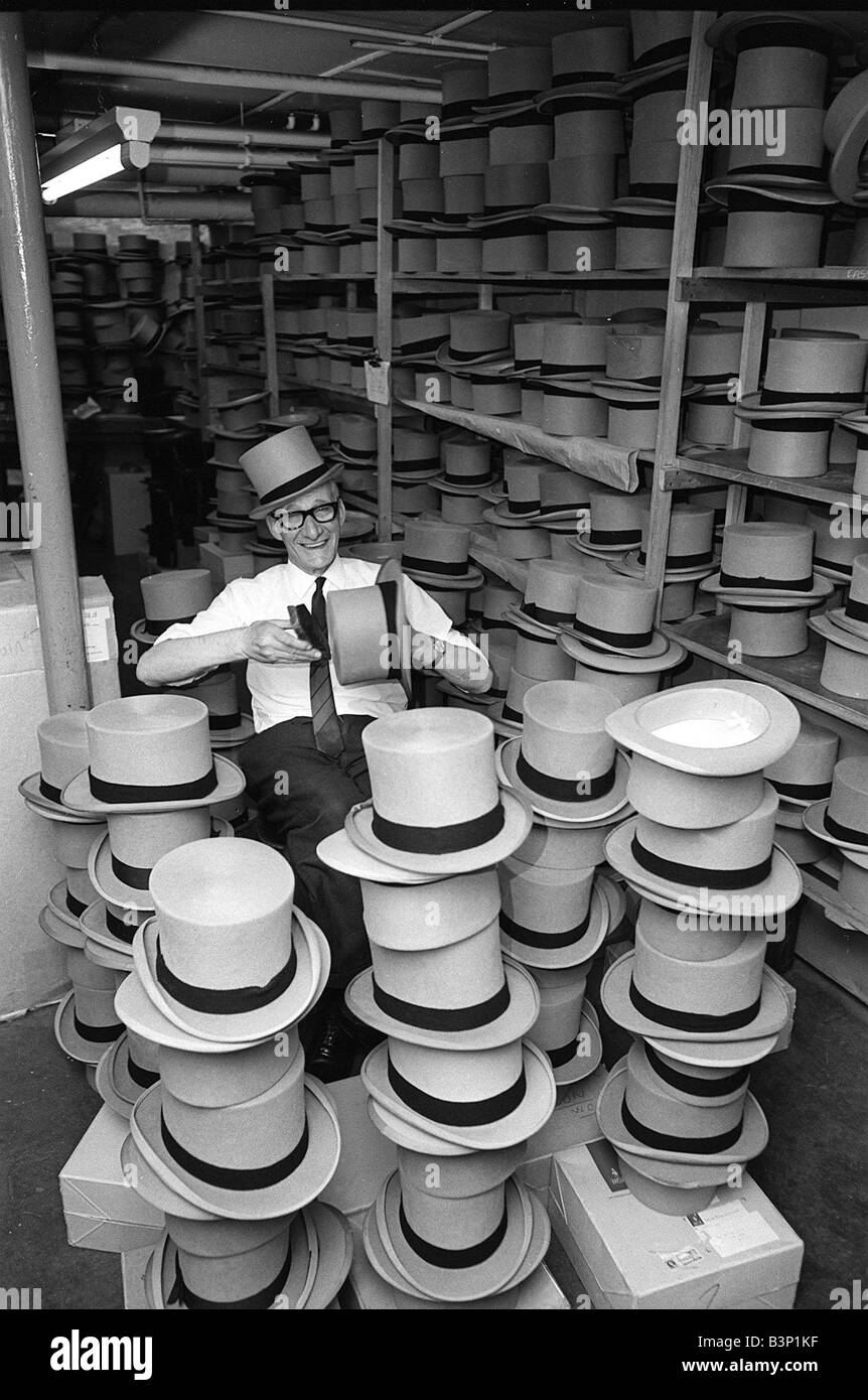 L'uomo felicemente la spazzolatura top cappelli a una tuta la società di noleggio in preparazione per il Royal Ascot Giugno 1968 1960s Foto Stock