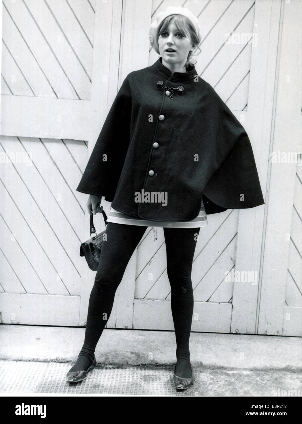 La moda degli anni sessanta il modello che indossa un capo nero berretto  bianco a strisce bianche e mini gonna con collant nero e scarpe tenendo una  borsetta Foto stock - Alamy