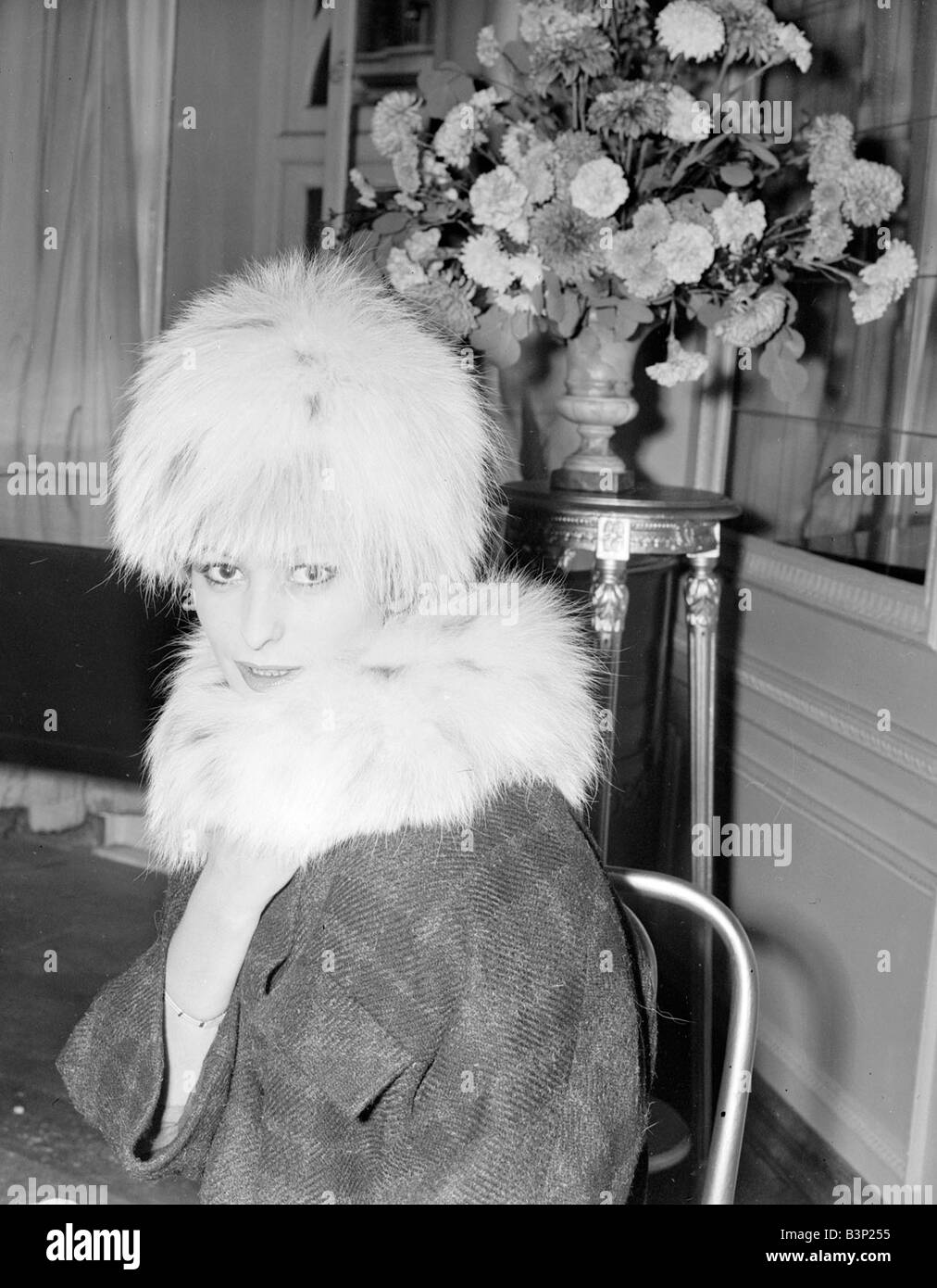 Modello Renate Banshat visto qui indossa un cappotto progettato da Hans Ostergard chiamato carmello abbigliamento moda Coat hat seduta floreale Novembre 1959 anni cinquanta Mirrorpix Foto di Park i neg detenute da Mirrorpix 2 11 1959 L7997 Foto Stock