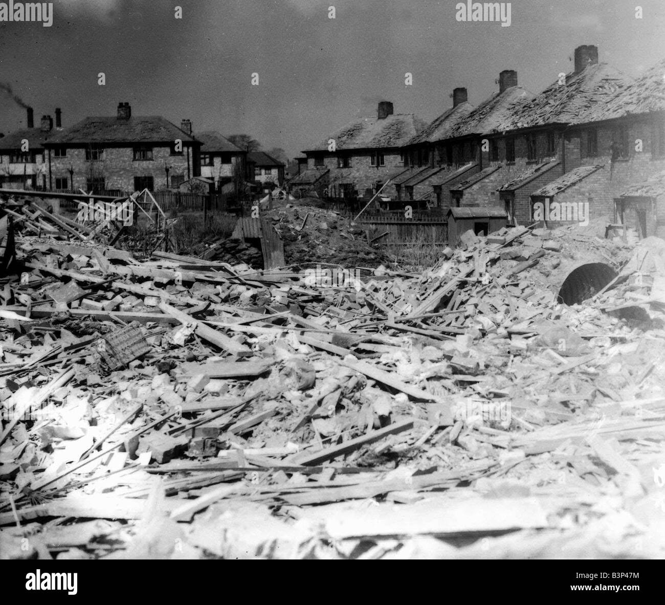 WW2 Merseyside Air Raid danni bomba 1940 la bomba ha danneggiato le case di Liverpool in seguito ad un bombardamento dalla Luftwaffe German Airforce durante il blitz un Anderson Air Raid Shelter può essere visto nel centro dell'immagine questi shelter è venuto in forma di kit sono stati realizzati in ferro corrigated una volta assemblato un foro nel giardino è stato scavato e il rifugio affondato nel foro Il rifugio è stato poi ricoperto di terra Foto Stock