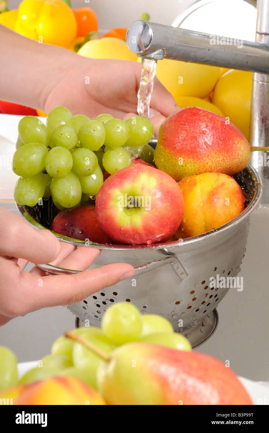 Uomo di lavaggio di frutta fresca in COLLANDER Foto Stock