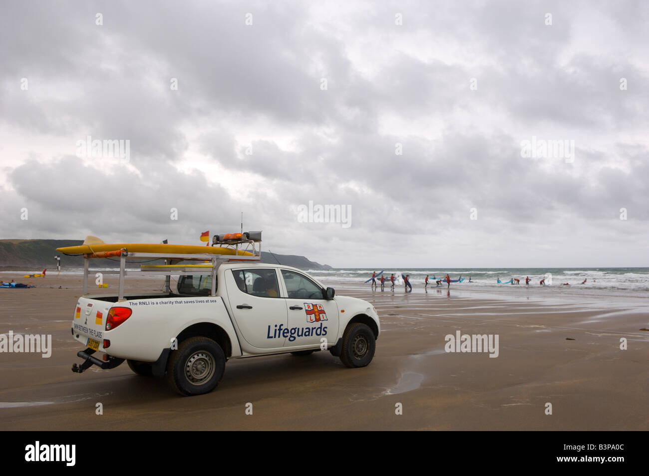 Bagnini sondaggio una spiaggia deserta da loro pick up truck a Widemouth Bay Cornwall Gran Bretagna Europa Foto Stock