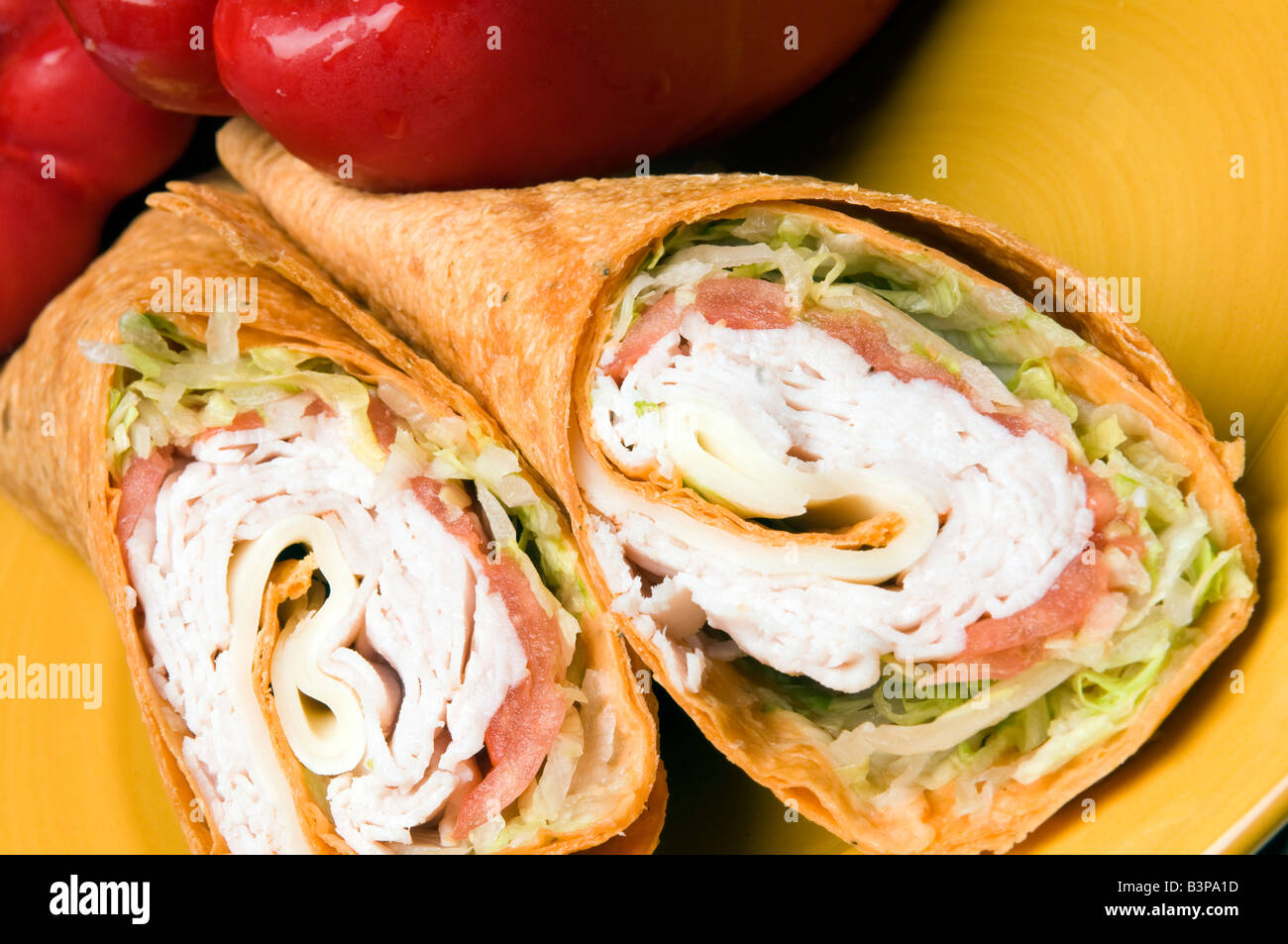 La Turchia e il formaggio svizzero avvolgere sandwich con peperoni rossi Foto Stock