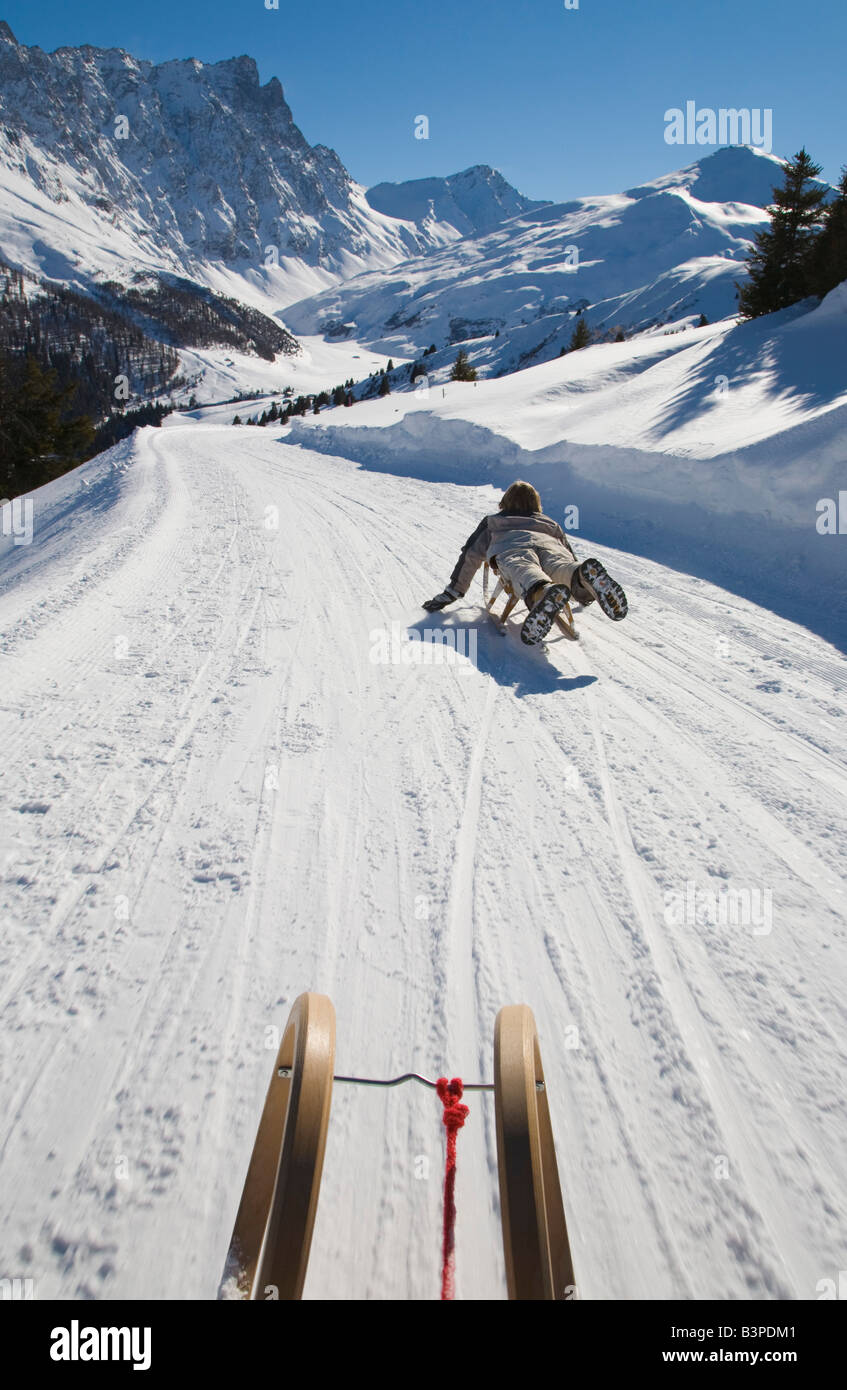 La Svizzera, dei Grigioni, Savognin, ragazzo (8-9) lo slittino, vista posteriore Foto Stock