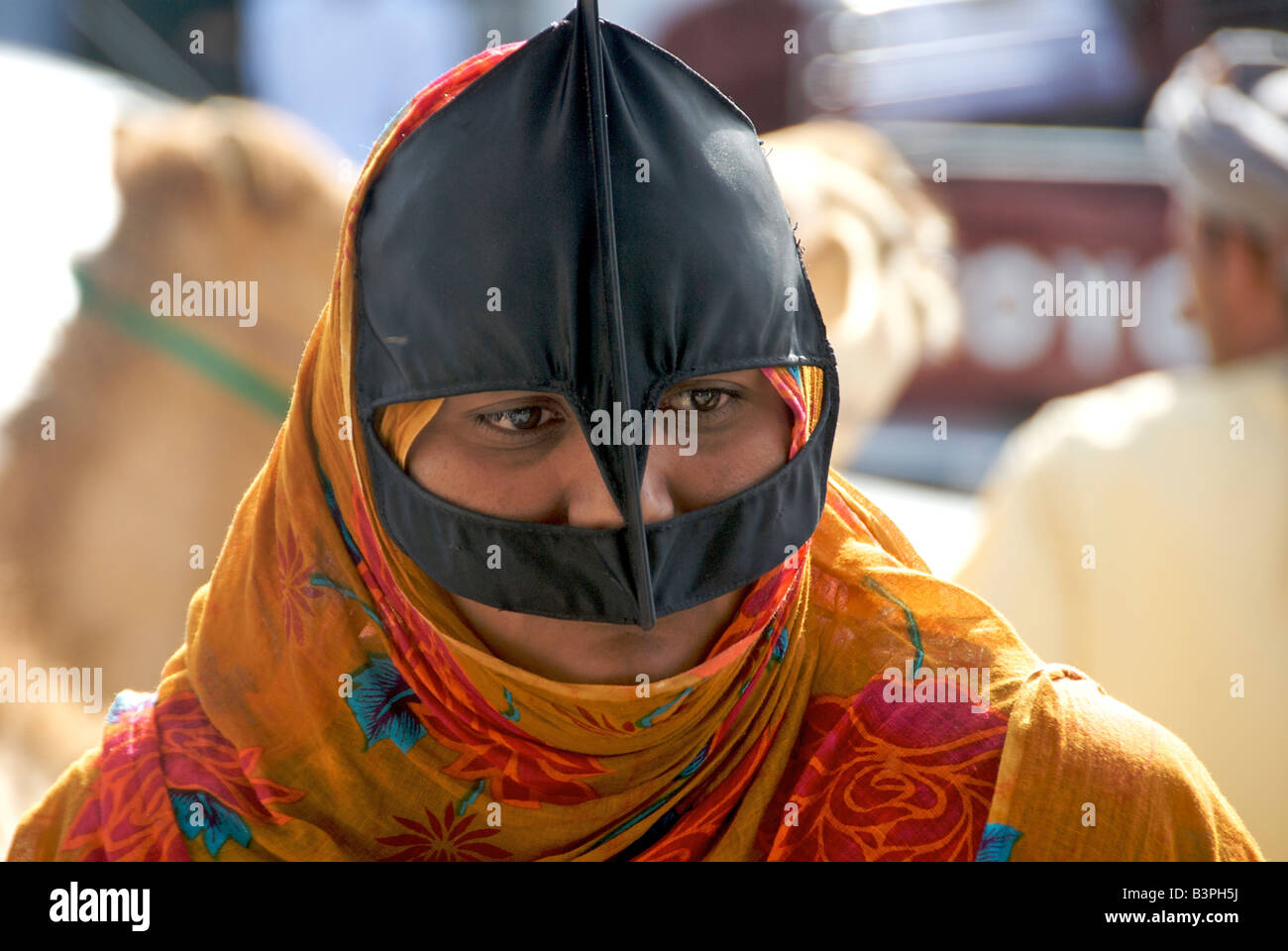 Close up beduino donna vestita di nero e arancio burka Sinaw Regione Sharqiya Sultanato di Oman Foto Stock