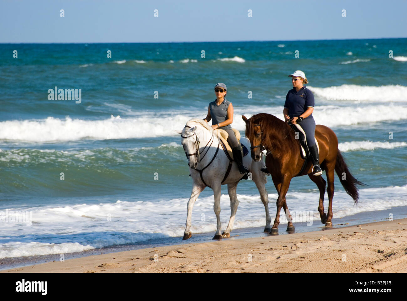 La gente a cavallo lungo la spiaggia di sabbia e la riserva naturale di L Albufera di Valencia Spagna Foto Stock