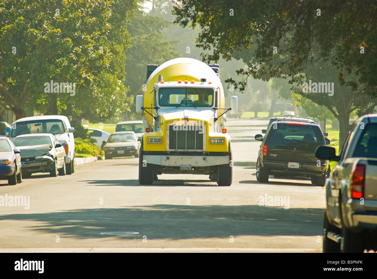 Un cemento giallo carrello avanza verso di te su una strada suburbana. Foto Stock