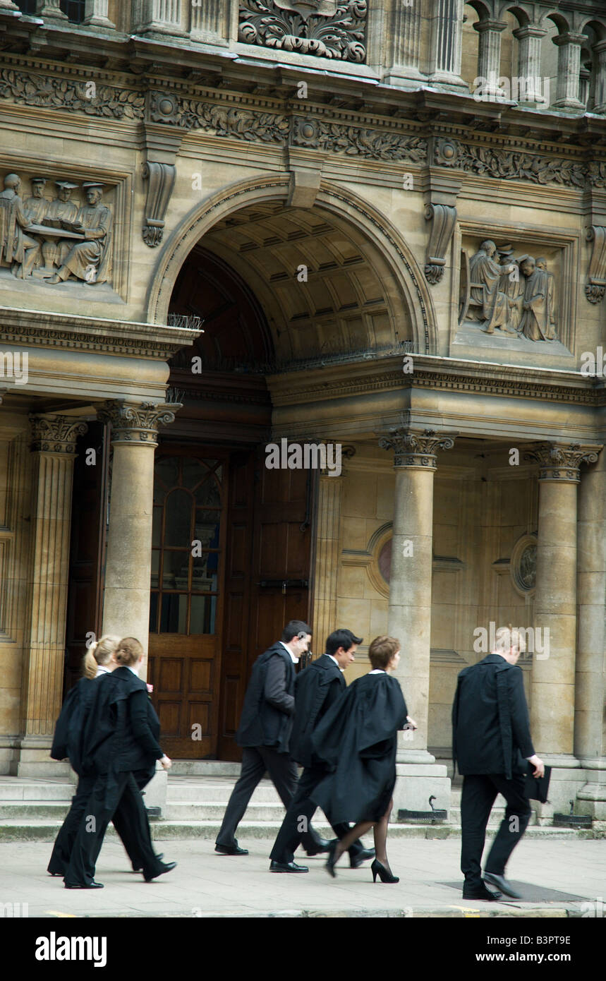Esame di Oxford gli studenti vestito in abiti e gonne e portante mortarboards a piedi passato l'esame scuole. Foto Stock