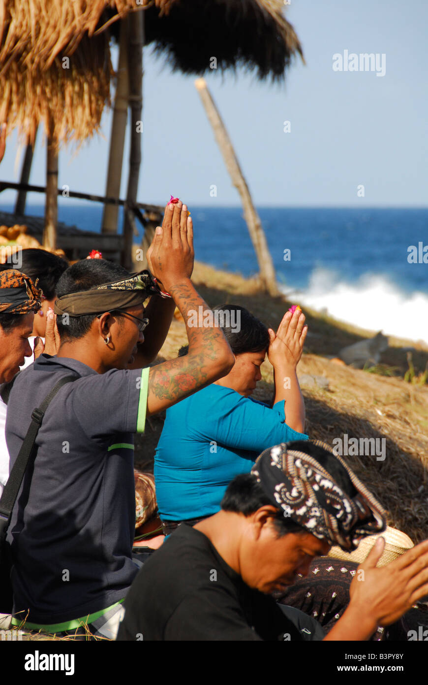 Persone in preghiera , cerimonia di cremazione /rituale finale, kusamba spiaggia , bali , Repubblica di Indonesia Foto Stock