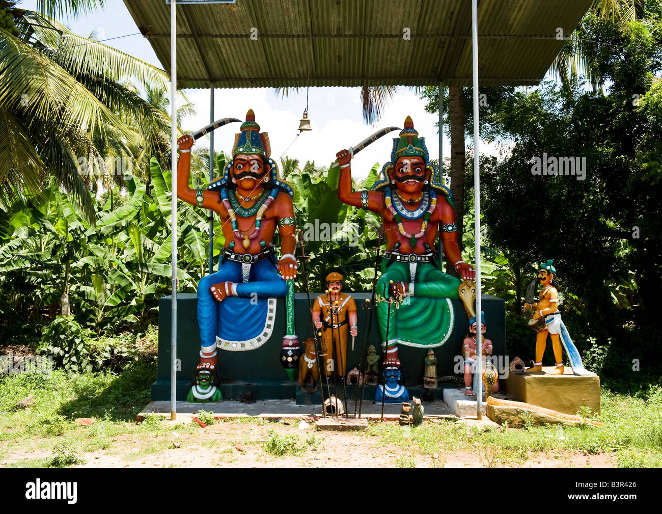 Uno dei più piccoli open-air templi con grandi statue dei guardiani delle aziende di grandi dimensioni sulla principale autostrada nella parte occidentale del Tamil Nadu. Foto Stock