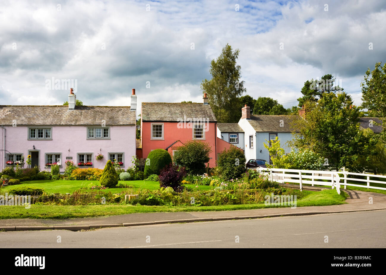 Piuttosto dipinte di casette a schiera nel villaggio di Caldbeck, nel distretto del lago, England, Regno Unito Foto Stock