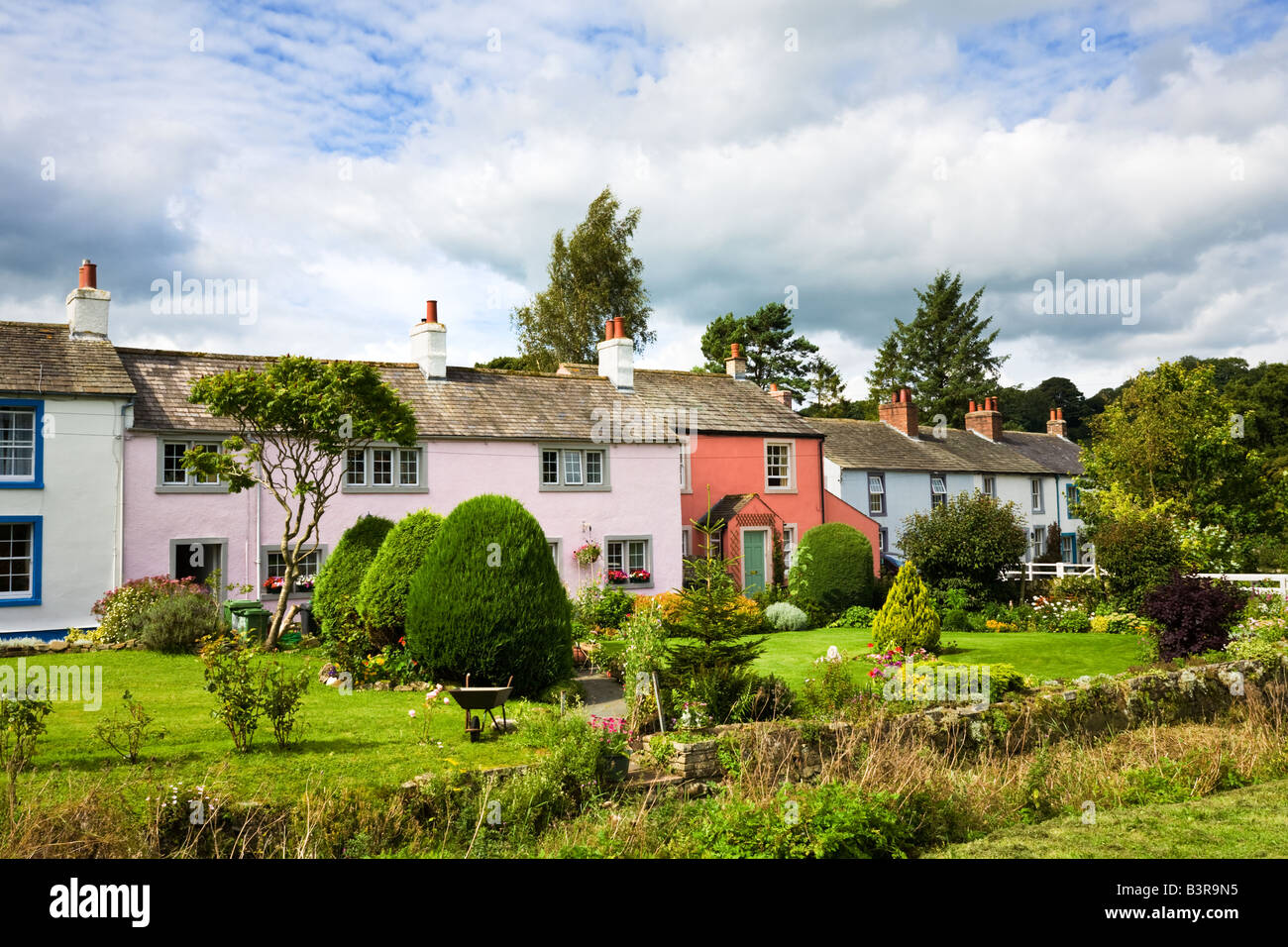 Piuttosto dipinte di casette a schiera nel villaggio di Caldbeck, nel distretto del lago, Cumbria, England, Regno Unito Foto Stock