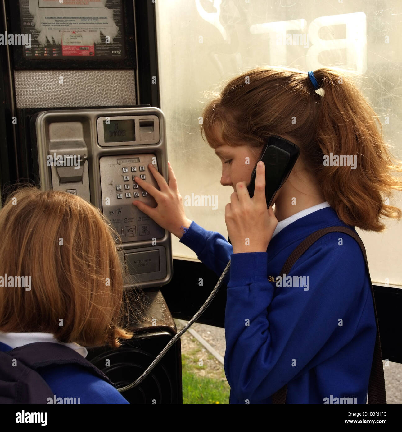 Bambino usando callbox telefonando da un telefono a gettoni che BT tendono a rimuovere da questo sito Foto Stock