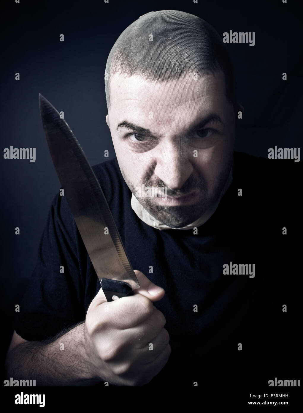 Brutto penale con le calze su viso e il coltello in mano Foto Stock