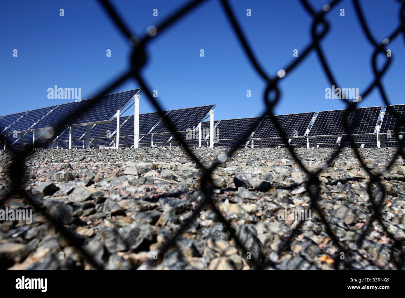 Un solare elettricità la generazione di array è visto dietro una recinzione in Brockton Massachusetts Foto Stock