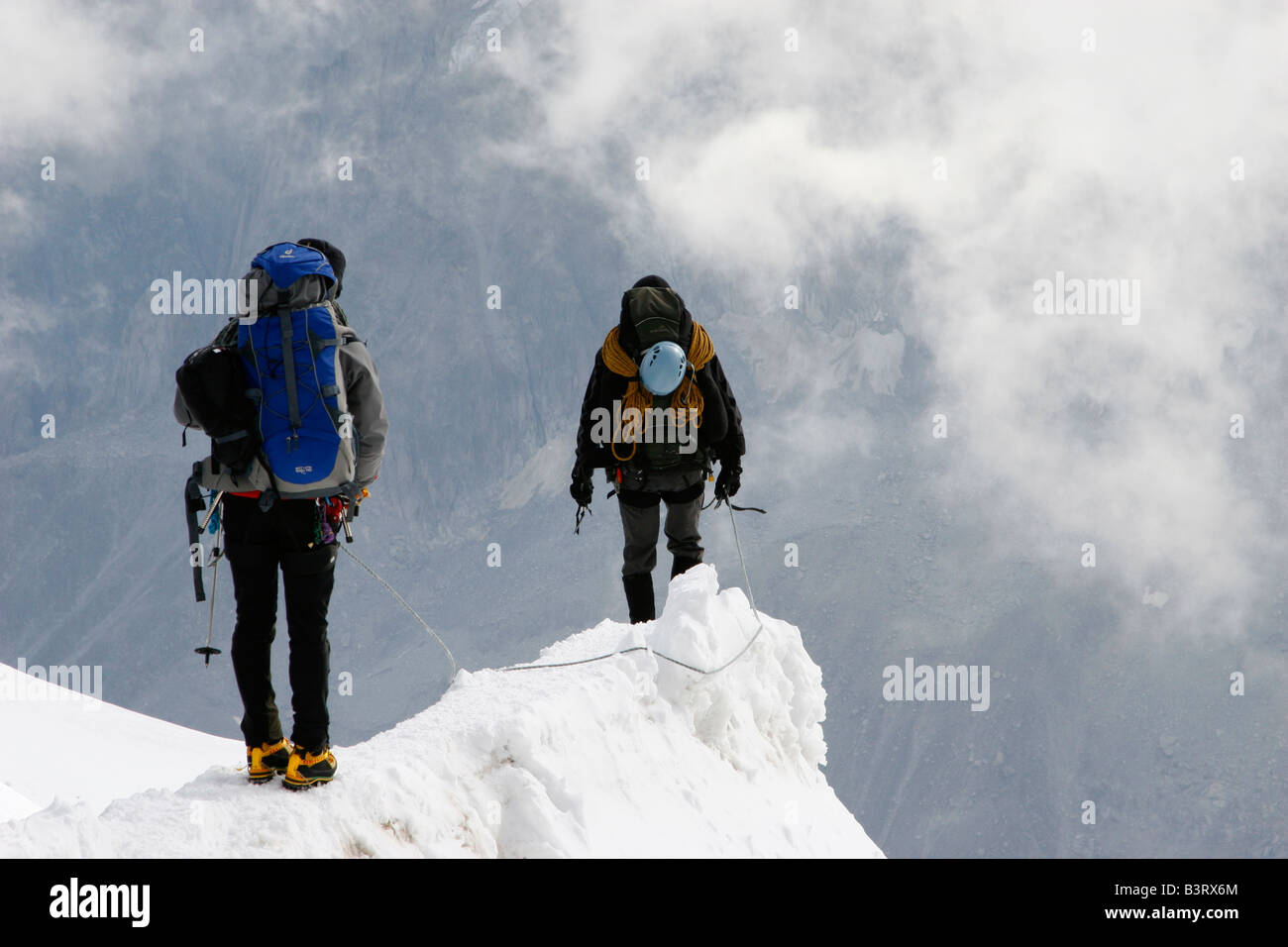 Due alpinisti cautamente scendere dal vertice del Aigulle du Midi vicino a Chamonix Mont Blanc nelle Alpi francesi Foto Stock