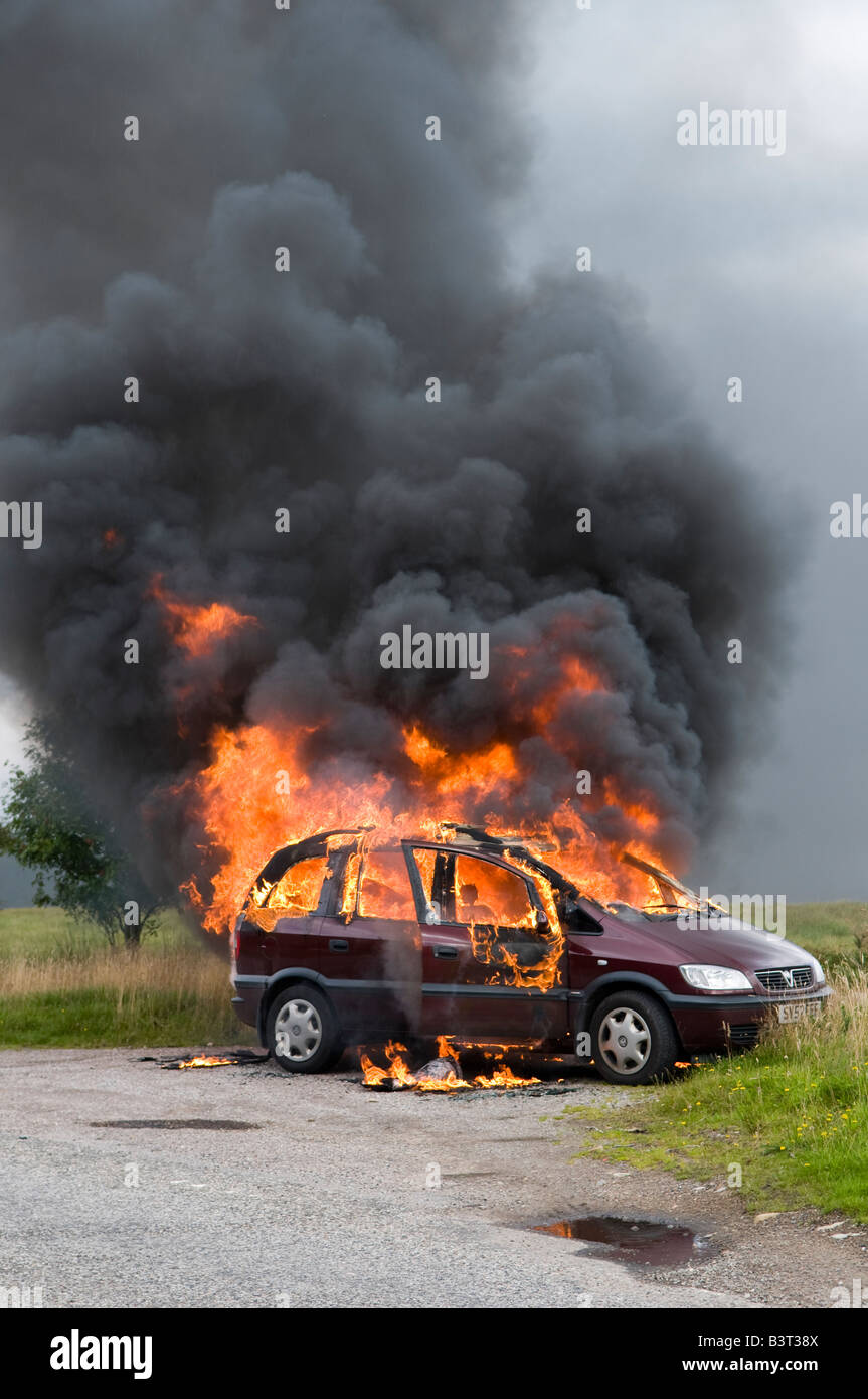 La fortuna di un fuga per il conducente di questa vettura che scoppia in fiamme in una remota strada rurale in Scozia. Foto Stock